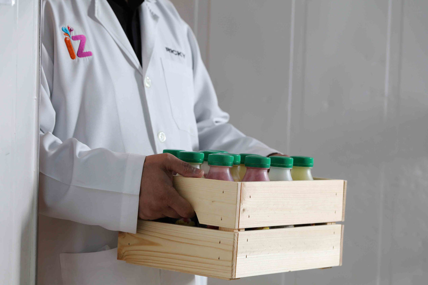 IZ Juice staff carrying a crate of fresh bottled juices